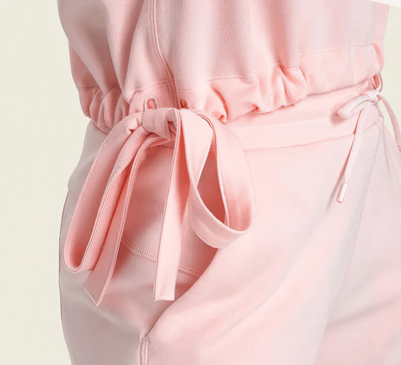 Close-up of pink sports crop T-shirt with adjustable hem, highlighting breathable fabric and sleek design for yoga or running.